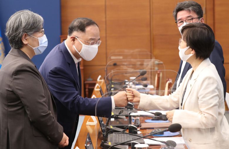 추가세수가 들어왔지만, 정부가 지출을 줄일 생각을 하지 않으면서 재정적자 행진은 계속될 전망이다. 7일 청와대에서 열린 제3차 코로나19 대응 특별방역점검회의에서 홍남기 경제부총리 겸 기획재정부 장관(가운데)과 기모란 청와대 방역기획관이 인사하고 있다. 왼쪽은 정은경 질병관리청장. [연합]