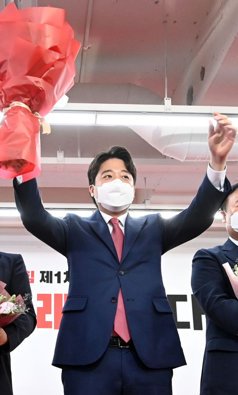 이준석 국민의힘 당 대표가 지난 11일 오전 서울 여의도 국민의힘 당사에서 열린 1차 전당대회에서 당 대표로 당선 된 뒤 꽃다발을 들고 인사하고 있다. [연합]