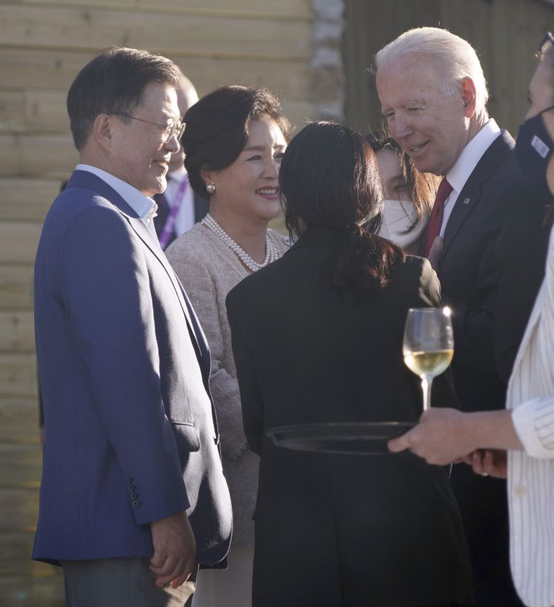 G7 정상회의에 참석 중인 문재인 대통령 부부와 조 바이든 미국 대통령이 12일 오후(현지시간) 영국 콘월 카비스베이 호텔 앞 해변에 마련된 만찬장에서 에어쇼를 기다리며 환담을 나누고 있다. 연합뉴스