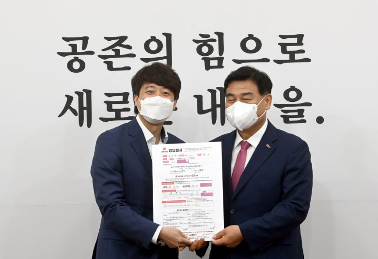 이준석 국민의힘 대표(왼쪽)가 1일 서울 여의도 국회에서 열린 최고위원회의에 앞서 일괄복당 1호인 심규언 무소속 동해시장의 입당서를 받고 있다. [연합]