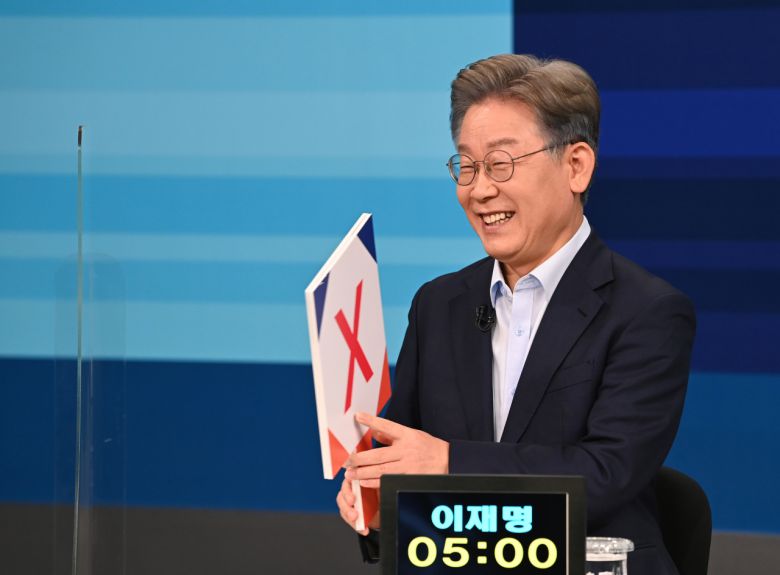 더불어민주당 대선 예비후보자인 이재명 경기지사가 5일 서울 마포구 JTBC 스튜디오에서 합동 TV토론에서 'OX' 퀴즈판을 들고 미소짓고 있다. [국회사진기자단]