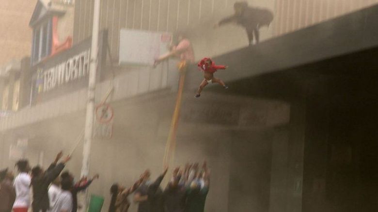 불이 난 건물에서 두 돌을 앞둔 딸을 건물 아래로 던진 남아공의 여성과 아이를 구조한 주민들. [BBC뉴스 캡처]