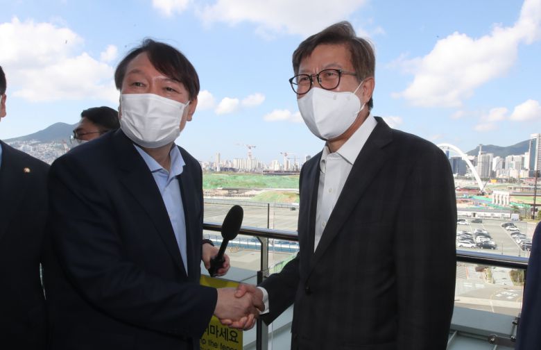 윤석열 전 검찰총장이 지난 27일 오전 부산 북항재개발 현장을 살펴보고 박형준 부산시장과 악수하고 있다. [연합]