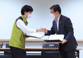 나순자 보건의료노조 위원장(왼쪽)과 권덕철 보건복지부 장관이 2일 새벽 서울 영등포구 의료기관평가인증원에서 13차 노정실무교섭이 타결된 뒤 서명한 합의문을 교환하며 인사하고 있다. [연합]