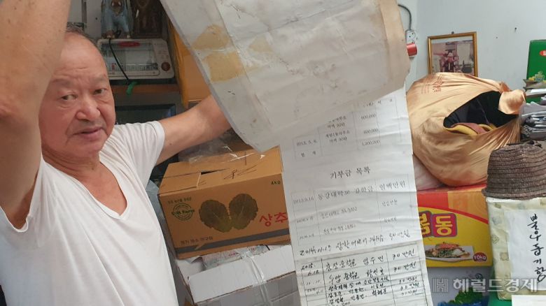 대인시장에서 야채가게를 운영하는 정안식 사장은 10여년 넘게 장사해서 번돈을 지역사회에 기부해 왔지만 현재는 임대료도 못 낼 처지다. 그가 인근 학교에 장학금으로 기부한 기탁서를 보여주고 있다.
