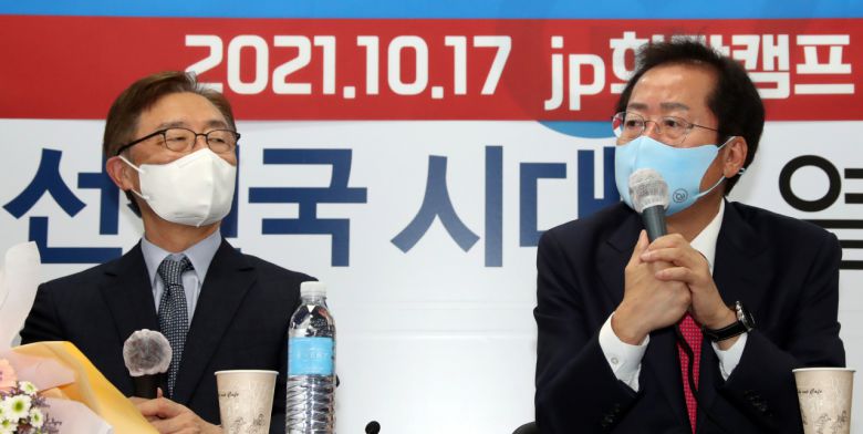 홍준표 국민의힘 대선 경선 후보(오른쪽)와 최재형 전 감사원장(왼쪽)이 17일 오전 서울 여의도 홍준표 캠프 사무실에서 열린 최 전 감사원장 영입 행사에서 꽃다발을 들고 포즈를 취하고 있다. [연합]