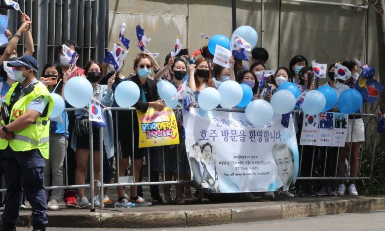 14일 오후 시드니 시내 한 호텔앞에서 교민들이 문재인 대통령의 시드니 방문을 환영하며 태극기 등을 흔들고 있다. 연합뉴스