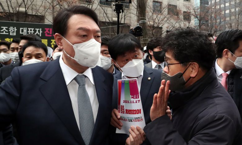 15일 오전 한국노총 간담회를 위해 서울 여의도 한국노총을 찾은 국민의힘 윤석열 대선 후보가 건물 밖에서 기자회견을 하던 한상균 권리찾기유니온 대표(전 민주노총 위원장)를 만나 '근로기준법 개정 촉구 입법청원서'를 전달받고 있다. [국회사진기자단]