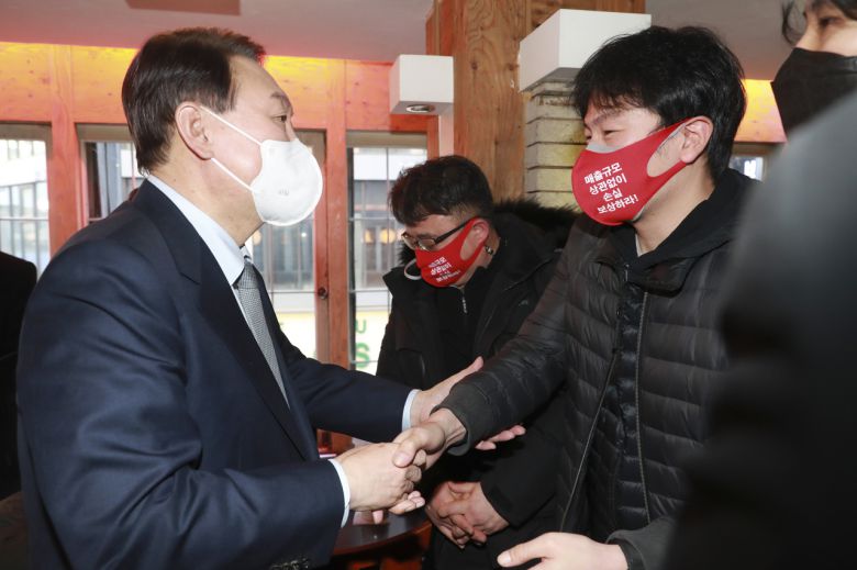 윤석열 국민의힘 대선 후보가 2일 오후 서울 종로구 한 음식점에서 열린 코로나19 자영업 피해 현장 간담회를 마치고 상인들을 위로하고 있다. [연합]