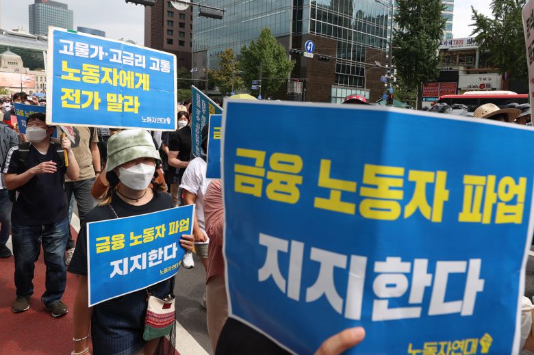 전국금융산업노동조합 총파업 참가자들이 16일 서울 중구 코리아나호텔 앞에서 집회를 마친 뒤 세종대로를 따라 용산 대통령실 방향으로 행진하며 손팻말을 들고 있다. 연합뉴스