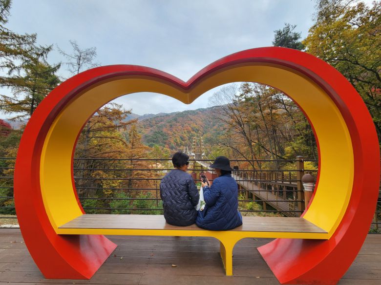 좌구산 명상구름다리 너머 하트 조형물에서 정담을 나누는 모녀