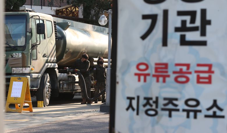 화물연대의 총파업이 13일째로 접어든 6일 서울 한 주유소에서 군 관계자들이 저장고에 기름을 넣고 있다. 화물연대의 파업으로 기름이 동난 주유소는 서울 35곳, 경기 20곳, 강원 12곳, 충남 11곳, 충북 8곳, 대전 7곳, 인천 1곳, 전북 1곳, 전남 1곳 등 전국적으로 96곳에 이른다. [연합]