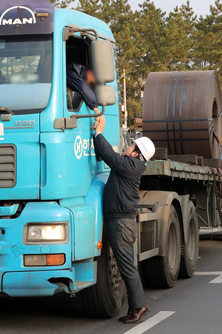 민주노총 공공운수노조 화물연대본부(화물연대)의 파업(운송거부)이 이어지는 가운데 원희룡 국토교통부 장관이 7일 경북 포항시 남구 포스코 포항제철소 앞에서 화물 운송에 나선 화물차 기사의 손을 까치발을 들어 두 손으로 잡고 있다. [연합뉴스]