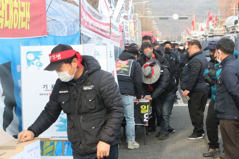 민주노총 공공운수노조 화물연대본부(화물연대) 대전본부 소속 조합원들이 9일 오전 대전 대덕구 대덕우체국 앞 거점 시위 현장에서 총파업 철회 찬반 투표를 진행하고 있다. [연합]