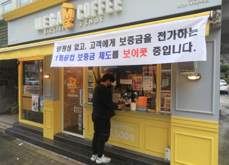 전국에서 처음으로 제주도 내 일부 프랜차이즈 매장을 대상으로 일회용컵 보증금제도가 실시된 2일 오전 제주시 연동의 한 프랜차이즈 카페에 보증금제도를 보이콧한다는 현수막이 걸려 있다. [연합]