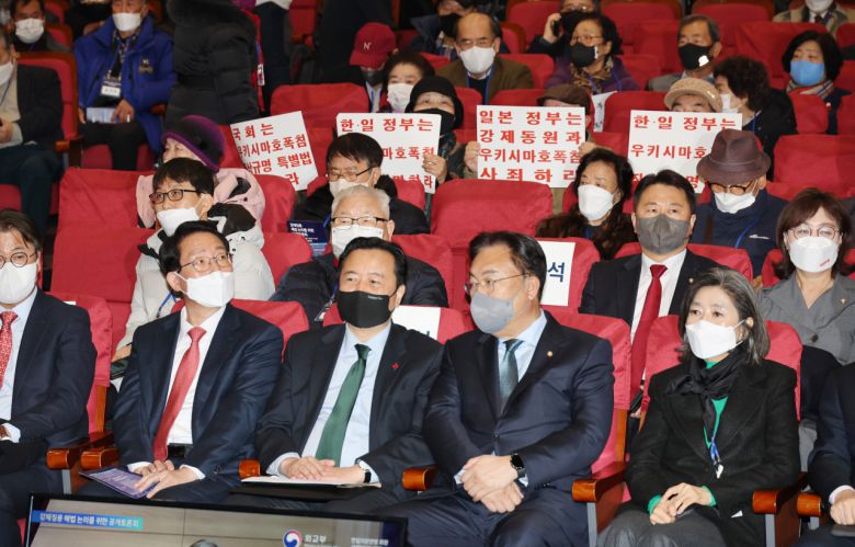 12일 오전 서울 여의도 국회 의원회관에서 열린 강제징용 해법 논의를 위한 공개토론회에서 참석자들이 피켓을 들고 있다. [연합]