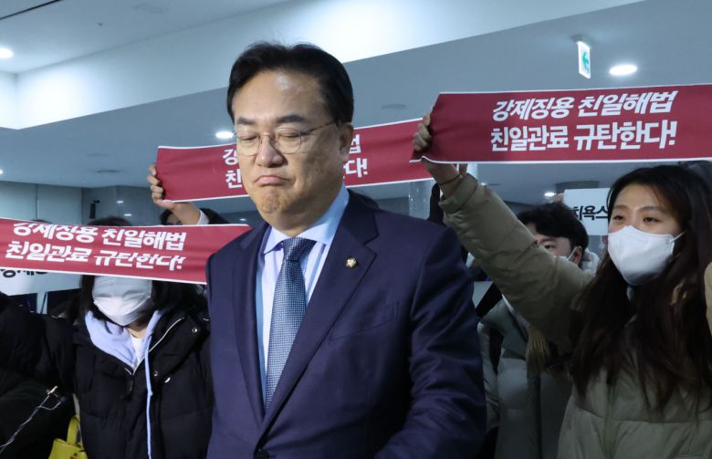 한일의원연맹 회장인 국민의힘 정진석 비상대책위원장이 12일 서울 여의도 국회 의원회관에서 열린 강제징용 해법 논의를 위한 공개토론회에 참석한 뒤 이동하며 겨레하나 회원들의 항의를 받고 있다. [연합]