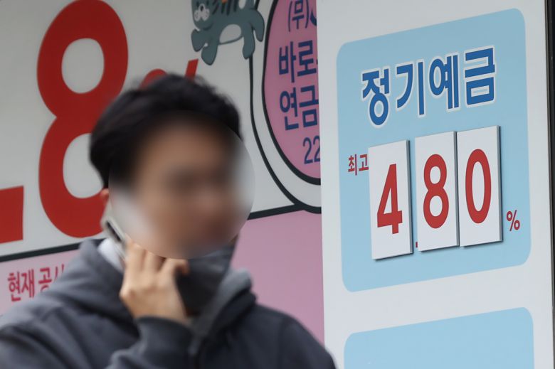 서울 한 상호금융의 예적금 안내문 앞을 시민이 지나가고 있다.[연합]