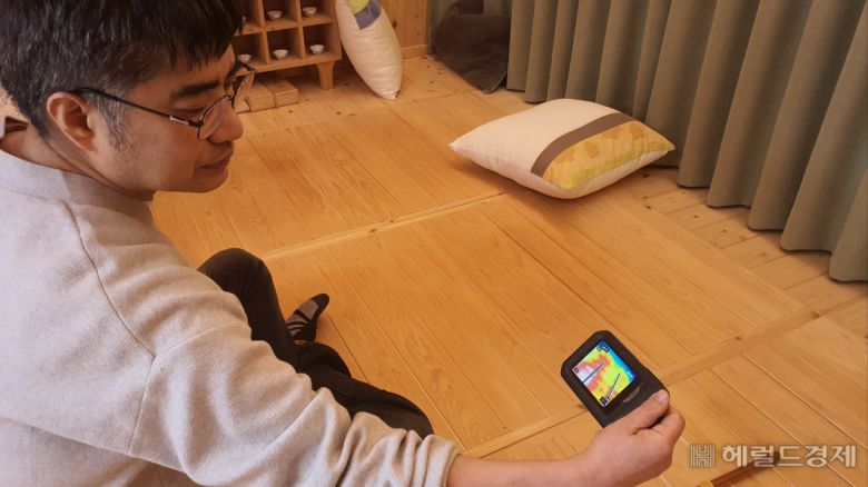 양철훈 이사가 편백온돌구들 테스트베드에서 온도측정기로 테스팅을 진행중이다. 서인주