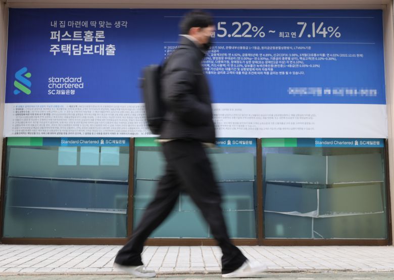 서울 한 시중은행의 대출 안내문 앞을 시민이 지나가고 있다. [연합]