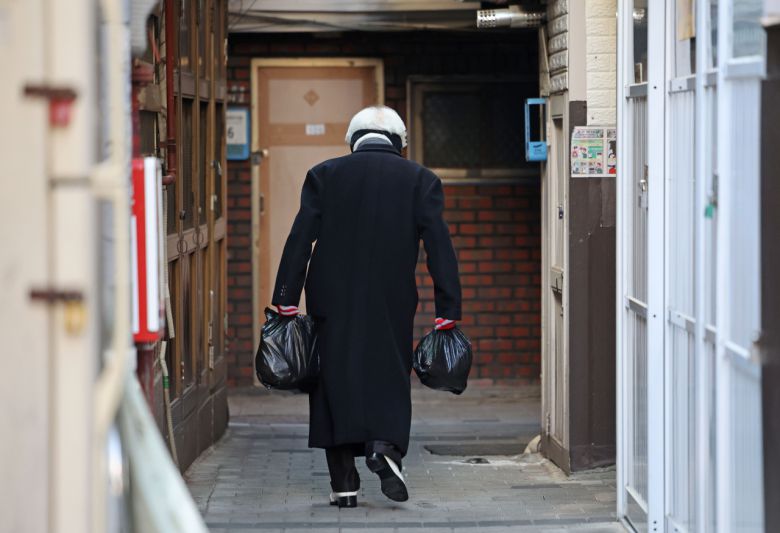 서울 종로구 돈의동 쪽방촌에서 한 주민이 발걸음을 재촉하고 있다. [연합]