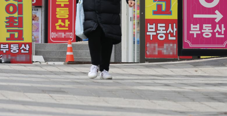 서울 한 부동산중개사무소 앞을 시민이 지나가고 있다.[연합]