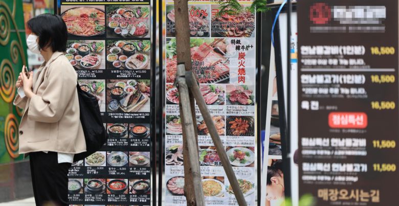 서울 중구 명동의 한 식당 안내문 앞을 시민이 지나가고 있다.[연합]
