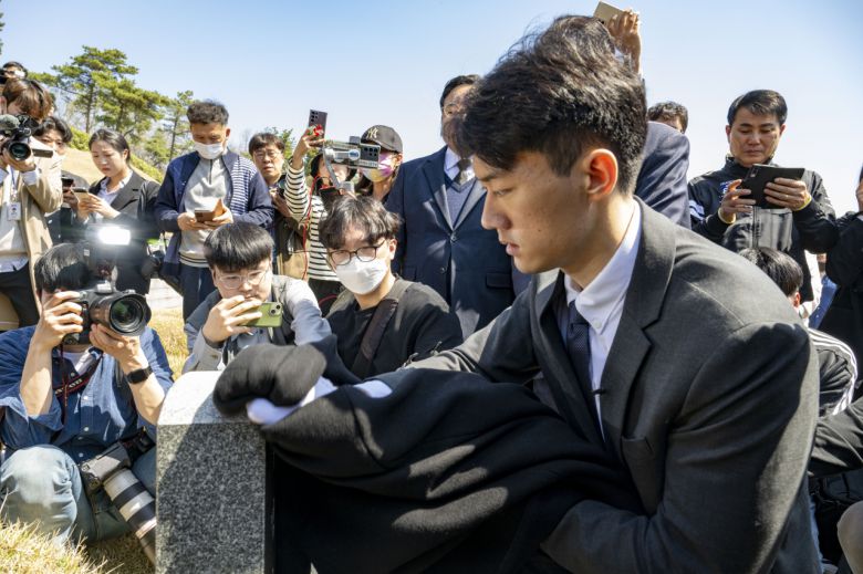 전직 대통령 고(故) 전두환 씨의 손자 전우원 씨가 31일 오전 광주 북구 운정동 국립 5·18민주묘지를 찾아 무명열사 묘비의 먼지를 옷으로 닦고 있다. [연합]