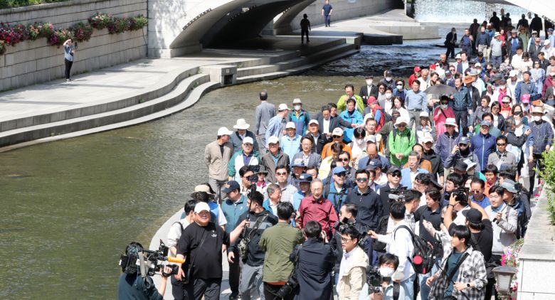 이명박 전 대통령이 15일 서울 청계천에서 '청계천을 사랑하는 모임'(청사모) 구성원들과 옛 참모들과 함께 산책하고 있다. 청계천 복원사업은 이 전 대통령의 서울시장 재임 시절 대표적인 치적 중 하나로 꼽힌다. [공동취재]