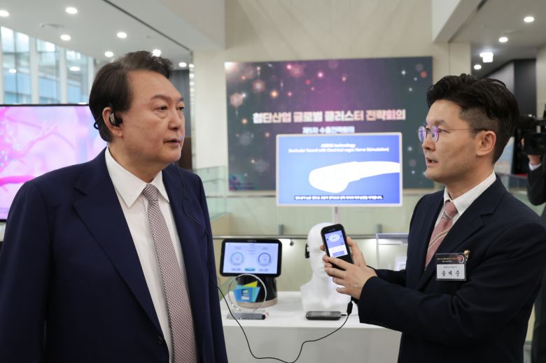 윤석열 대통령이 1일 서울 강서구 서울창업허브 엠플러스에서 열린 제5차 수출전략회의에 앞서 ㈜뉴라이브 송재준 대표로부터 '소리클' 디지털 치료제에 대한 설명을 듣고 있다. [연합]