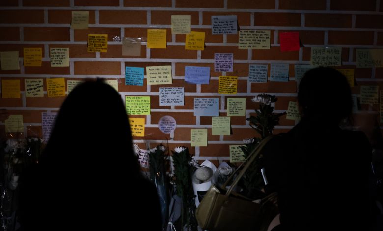 지난 20일 오후 서울 서초구 서이초등학교 강당 앞에서 추모객들이 강당 외벽에 국화꽃을 놓고 추모메시지를 적는 등 고인이 된 교사 A씨를 추모하고 있다. [연합]