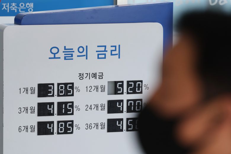 서울 한 저축은행의 예금 안내문 앞을 시민이 지나가고 있다.[연합]