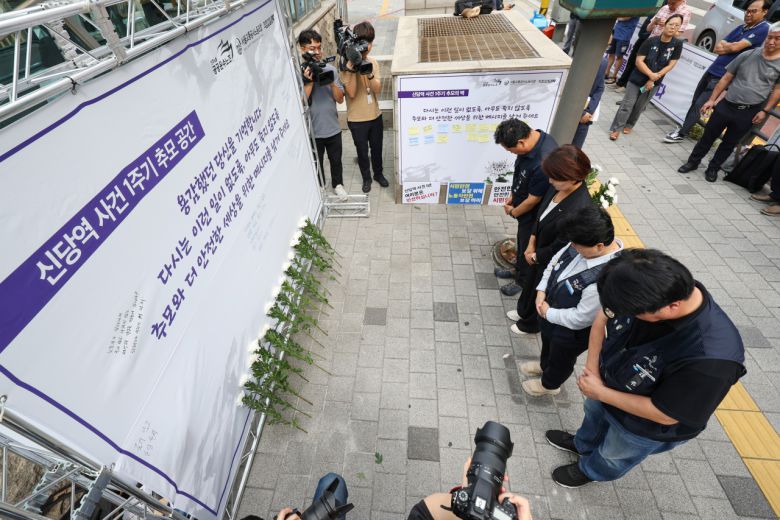 신당역 스토킹 살인사건 1주기 추모공간에서 민주노총, 공공운수노조, 서울교통공사노조, 직장갑질119 관계자들이 묵념하고 있다. [연합]