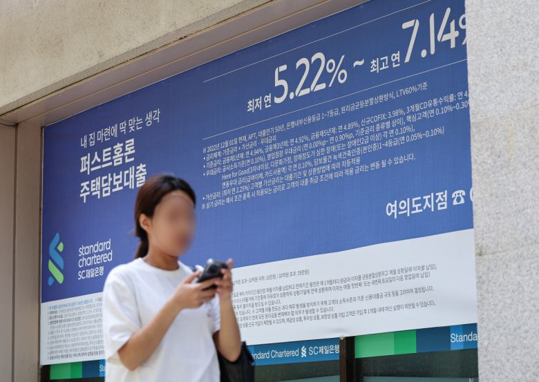 서울 한 시중은행의 대출 안내문 앞을 시민이 지나가고 있다.[연합]