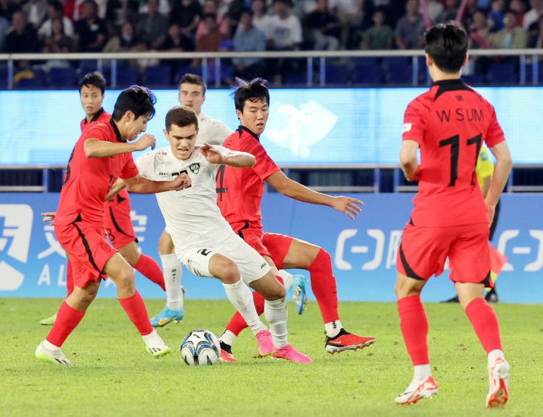4일 중국 항저우 황룽 스포츠센터 스타디움에서 열린 2022 항저우 아시안게임 남자축구 4강전 대한민국과 우즈베키스탄의 경기. 대표팀 이강인(왼쪽)과 박진섭이 우즈베키스탄 루스란베크 지야노프를 협력 수비로 막아내고 있다. [연합]