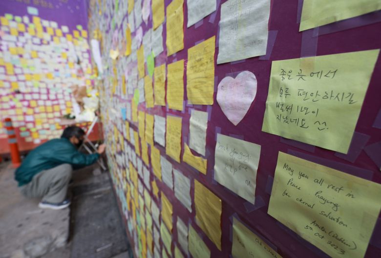 이태원 참사 1주기를 2주 앞둔 15일 서울 용산 이태원의 참사 골목에 설치된 '10.29 이태원 참사 기억의 길'에서 한 시민이 추모메세지를 붙이고 있다. [연합]