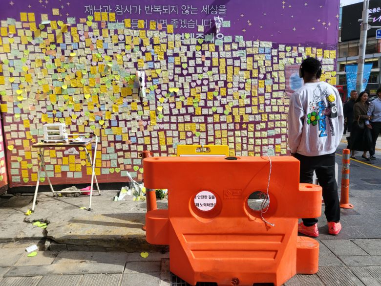이태원 참사 발생 장소 인근에 설치된 추모 공간에서 지난 22일 한 시민이 추모 메시지를 들여다 보고 있다. 박혜원 기자