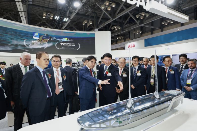 지난 24일부터 부산 벡스크에서 열린 ‘국제조선 및 해양산업전(KORMARINE 2023)’에서 HD현대가 미래 친환경·스마트 선박 관련 최신 기술들을 선보였다. 한영석(왼쪽 다섯번쨰) HD현대중공업 부회장이 이성권(왼쪽 네번째) 부산광역시 경제부시장에게 수소운반선 모형에 대해 설명하고 있다. [HD현대 제공]