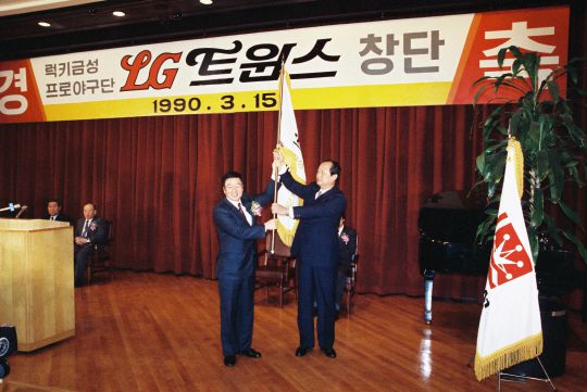 1990년 LG 트윈스 창단식에서 구본무(왼쪽) 선대회장이 조광식 초대단장에게 단기를 전달하는 모습 [LG 트윈스 제공]
