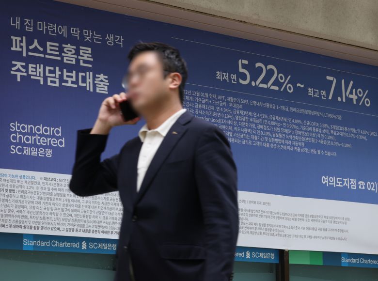 서울 한 시중은행의 대출 안내문 앞을 시민이 지나가고 있다.[연합]