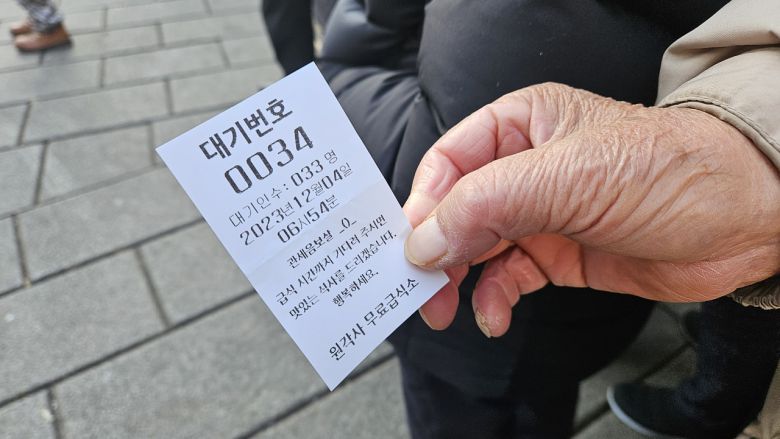 경기도 고양시에서 1시간 걸려 탑골공원에 도착한 박모(80) 씨가 원각사 노인 무료급식소에서 받은 번호표를 보여주고 있다. 박지영 기자.