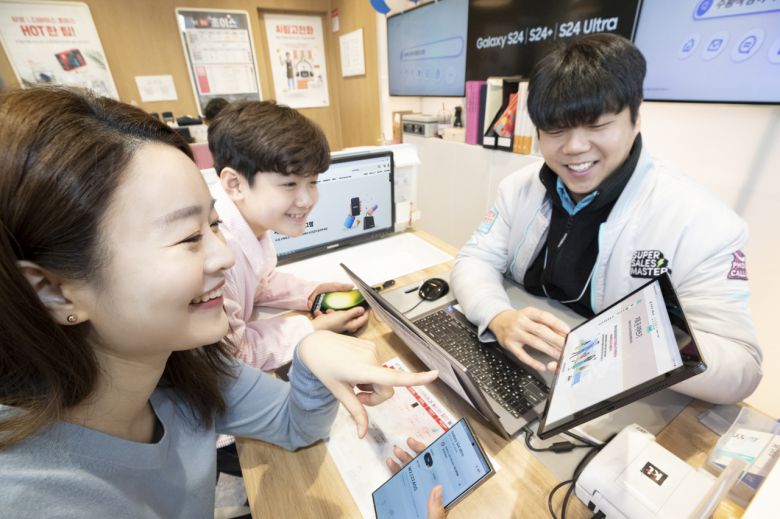 KT가 삼성전자와 함께 기존폰을 자녀에게 물려주는 ‘갤럭시 패밀리폰 프로그램’을 시행한다고 2일 밝혔다. KT플라자에서 엄마와 아들이 기존폰을 물려주고 받는 서비스를 소개받는 모습. [KT 제공]