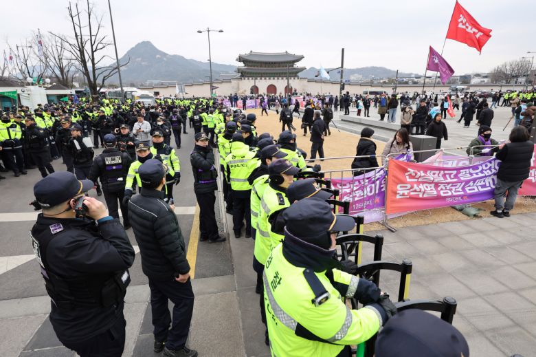 10·29 이태원 참사 유가족협의회·시민대책회의 관계자들이 3일 오후 '국민의힘·윤석열 정권 심판 대행진'을 열고 행진한 뒤 정부서울청사 인근 펜스에 현수막을 설치하고 있다. [연합]
