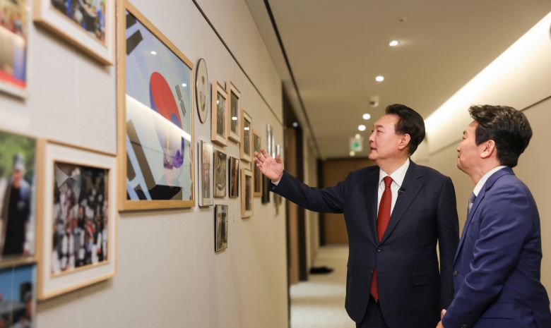 윤석열 대통령이 지난 4일 서울 용산 대통령실 청사에서 가진 KBS '특별대담 대통령실을 가다' 녹화를 마친 뒤 박장범 KBS 앵커에게 집무실 복도에 걸린 정상외교, 국정활동, 가족 사진 등을 소개하고 있다. [연합]