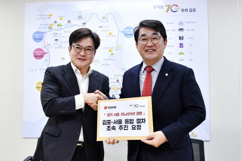 김병수 김포시장이 15일 오전 배준영 국민의힘 경기-서울 리노베이션 태스크포스(TF) 위원장에게 서울 편입 절차의 조속한 추진을 요청하는 건의문을 전달하고 있다. [연합]