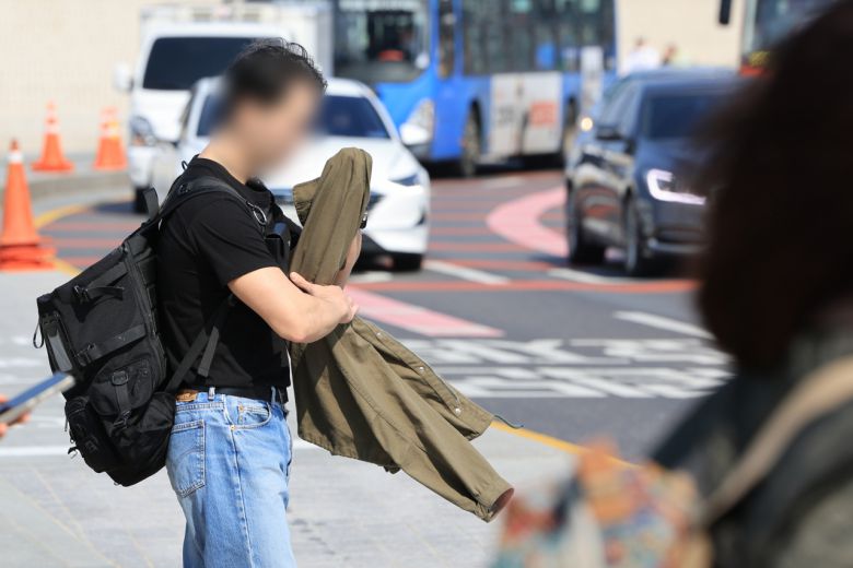 13일 오후 서울 경복궁 앞에서 반팔을 입은 시민이 신호를 기다리고 있다. [연합]