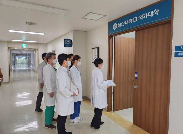 지난 25일 오후 울산대 의대 산하 수련병원 소속 교수들이 울산대 의대 로비에서 사직서를 제출하고 있다. [울산대 의대 비대위 제공]