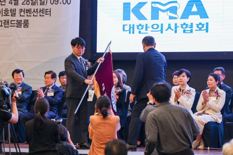 대한의사협회 임현택 차기 회장 당선인이 지난 28일 오전 서울 서초구 더케이호텔에서 열린 대한의사협회 제76차 정기대의원 총회에서 협회기를 건네받고 있다. [연합]