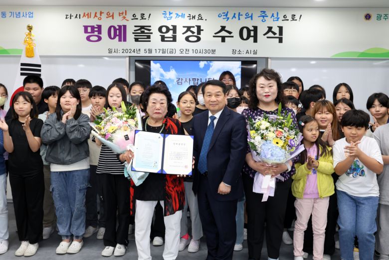 5·18민주화운동 기념일을 하루 앞둔 17일 광주 서구 양동초등학교에서 열린 5·18 당시 행방불명자 이창현 군 명예졸업장 수여식에서 임공진 학교장이 이창현 군 어머니 김말임 씨와 누나 이선영 씨에게 졸업장과 꽃다발을 전달한 뒤 기념사진을 찍고 있다.[연합]