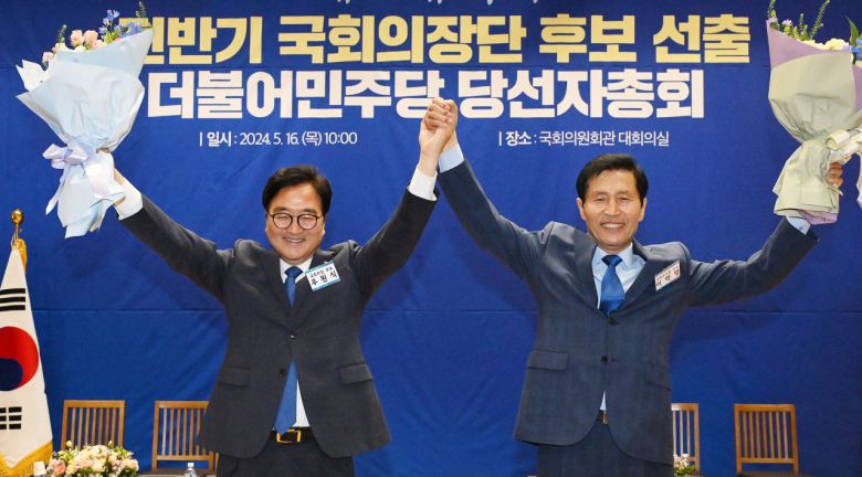 더불어민주당 국회의장 후보로 선출된 우원식 후보(왼쪽)와 국회부의장 후보로 선출된 이학영 후보가 16일 오전 국회 의원회관에서 열린 제22대 전반기 국회의장단 후보 선출을 위한 당선자 총회에서 꽃다발을 들고 두 팔을 들어 올리고 있다. 이상섭 기자